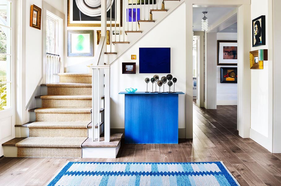 Décoration de la pièce d'entrée d'une maison avec un incroyable tapis et une console en verre bleue
