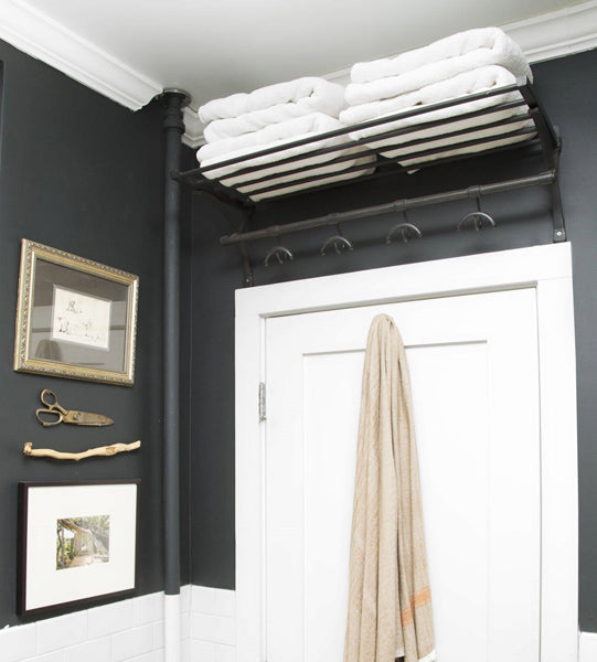 Idée décoration salle de bain avec un rack au dessus de la porte