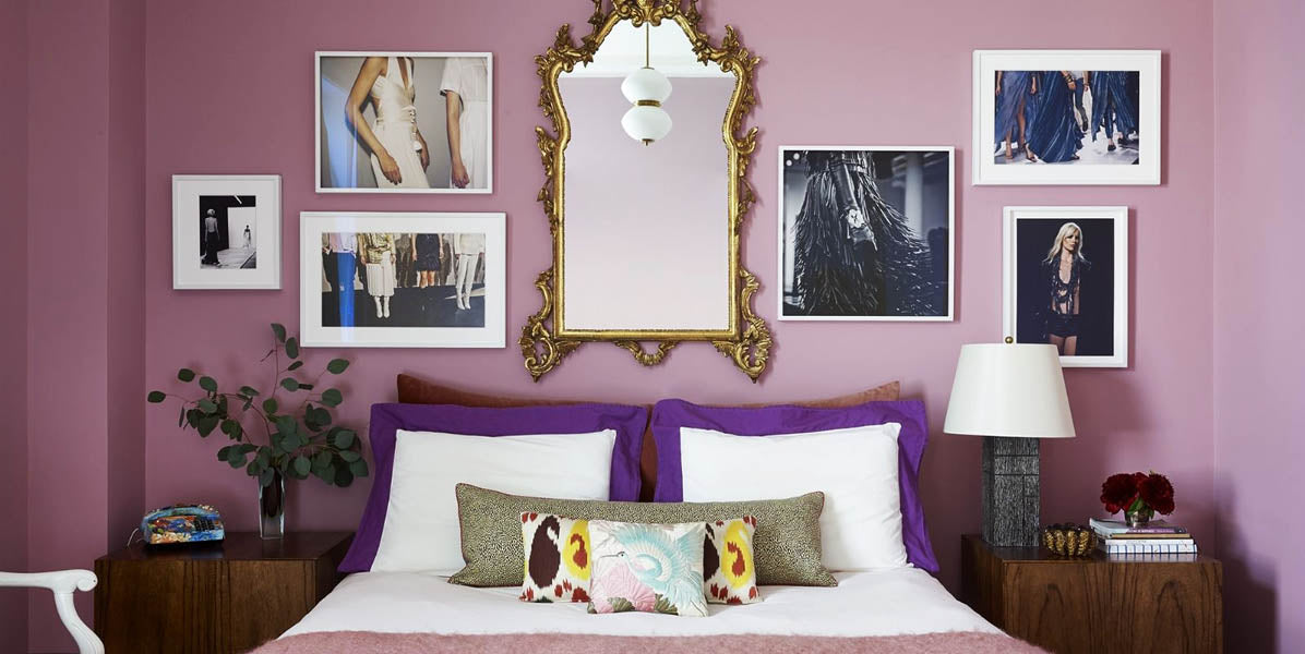 Photos sur le mur rose d'une chambre à coucher